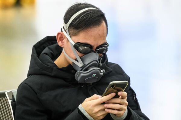 Пассажир в очках для плавания и маске на железнодорожной станции в Гонконге - Sputnik Казахстан