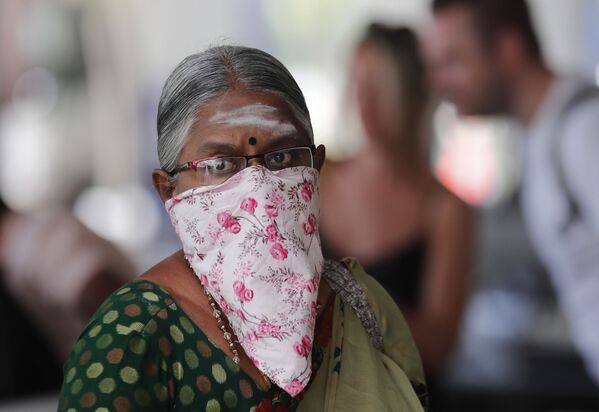 Пожилая индийская женщина в маске из платка в аэропорту Коломбо  - Sputnik Казахстан
