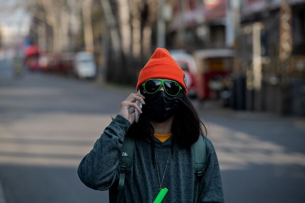 Девушка в маске и очках на пустынной улице Пекина  - Sputnik Казахстан