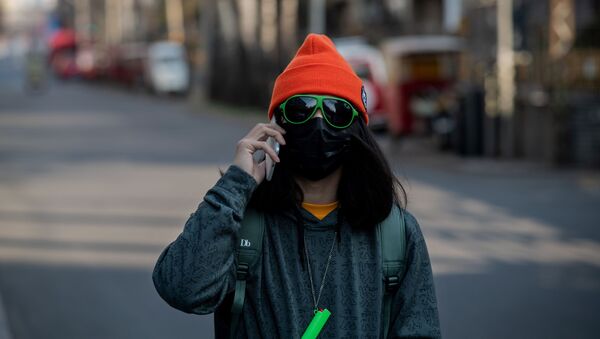 Девушка в маске и очках на пустынной улице Пекина  - Sputnik Казахстан