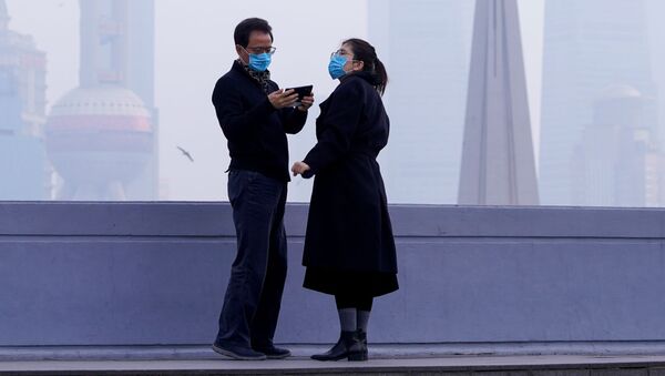 Люди в масках на мосту на фоне финансового района Пудун в Шанхае, Китай - Sputnik Казахстан