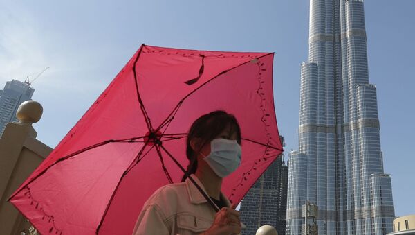 Женщина в маске у башни Бурдж-Халифа в Дубае, ОАЭ - Sputnik Казахстан