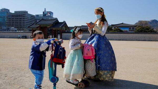 Женщина с детьми в защитных масках в Сеуле - Sputnik Казахстан