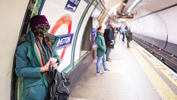Девушка в защитной маске на платформе метро в Лондоне - Sputnik Казахстан