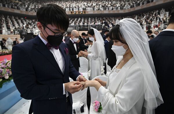 Couples wearing protective face masks attend a mass wedding ceremony organised by the Unification Church at Cheongshim Peace World Center in Gapyeong on February 7, 2020. - South Korea has confirmed 24 cases of the SARS-like virus so far and placed nearly 260 people in quarantine for detailed checks amid growing public alarm.  - Sputnik Казахстан