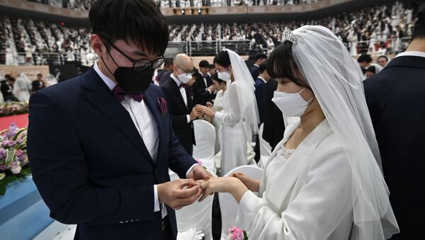 Жених в черной защитной маске и невеста в белой защитной маске во время массового бракосочетания, Южная Корея - Sputnik Казахстан