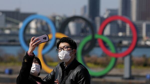 Люди делают селфи под олимпийскими кольцами в Токио, Япония - Sputnik Казахстан