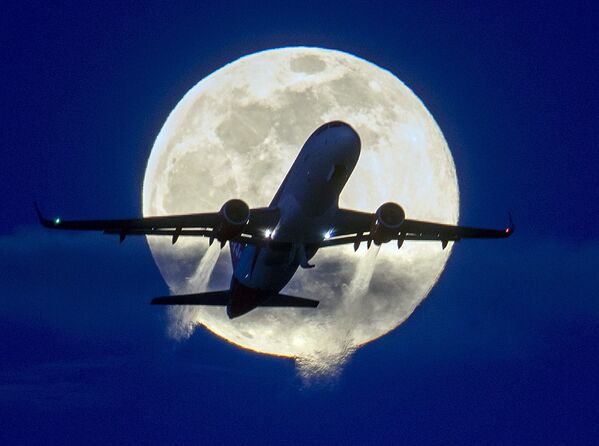 An aircraft passes the rising full moon at the airport in Frankfurt, Germany, Monday, March 9, 2020.  - Sputnik Казахстан