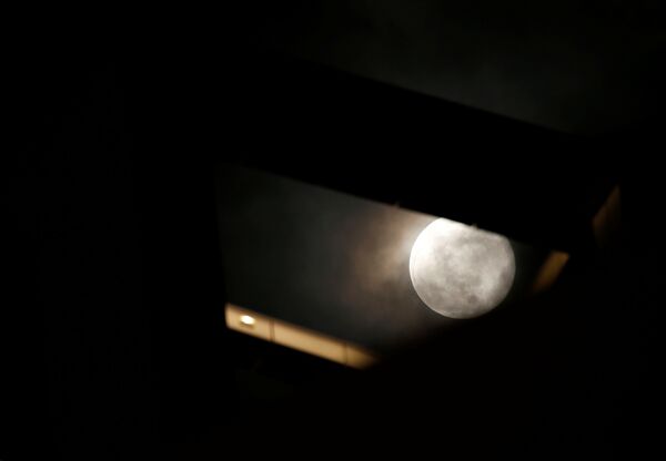 The super worm moon is seen behind a high rise building in St Julian's, Malta March 9, 2020.  - Sputnik Казахстан