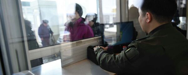 Сотрудник КПП кыргызско-казахской границы проверяет документы у граждан, архивное фото - Sputnik Казахстан