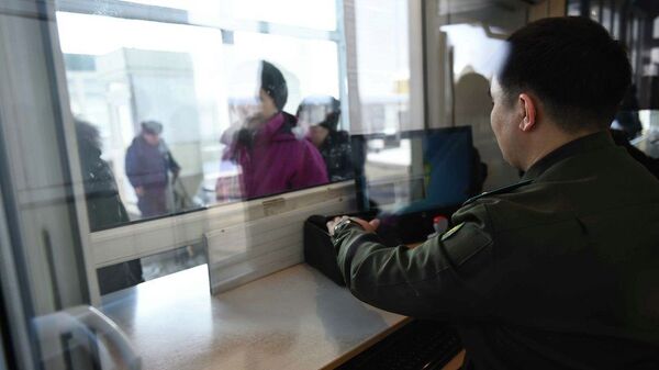 Сотрудник КПП кыргызско-казахской границы проверяет документы у граждан, архивное фото - Sputnik Қазақстан