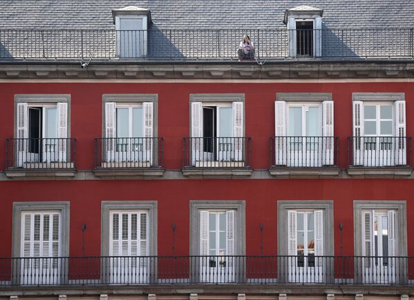 A woman sits on the roof of her home at Plaza Mayor square during partial lockdown as part of a 15-day state of emergency to combat the coronavirus disease outbreak in Madrid, Spain March 15, 2020.  - Sputnik Казахстан