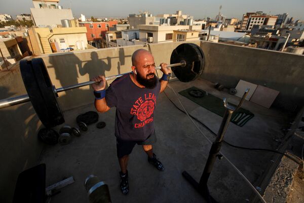 Osama Hussein trains on the roof of his house, while gyms closed as a preventive measure against coronavirus in Erbil, Iraq March 11, 2020. - Sputnik Казахстан