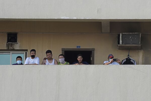 Foreign workers stand on the balcony of a building where a resident tested positive for coronavirus (COVID-19) in the Salmabad industrial area on the outskirts of the capital Manama on March 13, 2020. 
 - Sputnik Казахстан