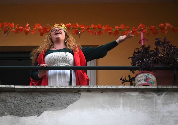 A woman sings from her balcony  Italian government continues restrictive movement measures to combat the coronavirus outbreak, in Rome, Italy March 14, 2020. 
 - Sputnik Казахстан
