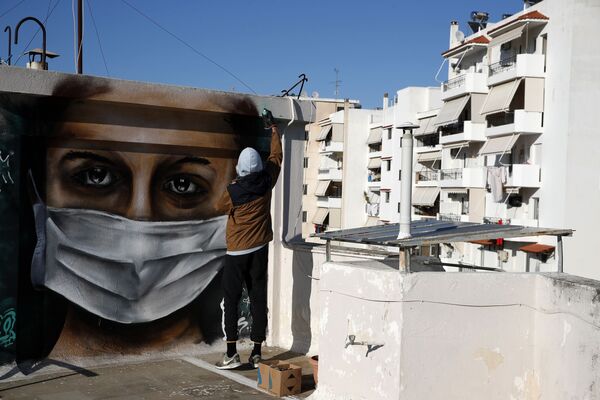 S.F., a 16-year-old Greek graffiti artist, spray-paints a design, a woman wearing a face mask referring to protection against coronavirus, on the roof of his apartment block in Athens, Tuesday, March 17, 2020. Greece has imposed a wide range of public safety measures to try and contain the coronavirus outbreak, including school and store closures. The vast majority of people recover from the new coronavirus. According to the World Health Organization, most people recover in about two to six weeks, depending on the severity of the illness. - Sputnik Казахстан