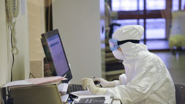 Медработник в защитном костюме во время дежурства в больнице - Sputnik Қазақстан