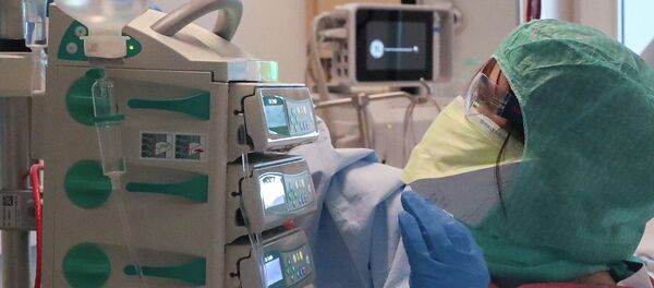 Медицинский работник в защитном костюме проверяет датчики  - Sputnik Казахстан