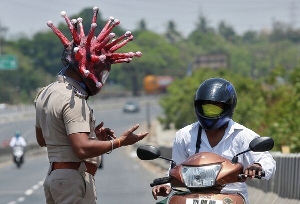 В Индии полицейский в шлеме с изображением коронавируса останавливает водителей и просит сидеть дома - Sputnik Казахстан