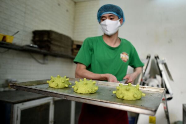 Вьетнамский шеф-повар Данг Ван Ху в медицинской маске с булочками в форме модели коронавируса - Sputnik Казахстан