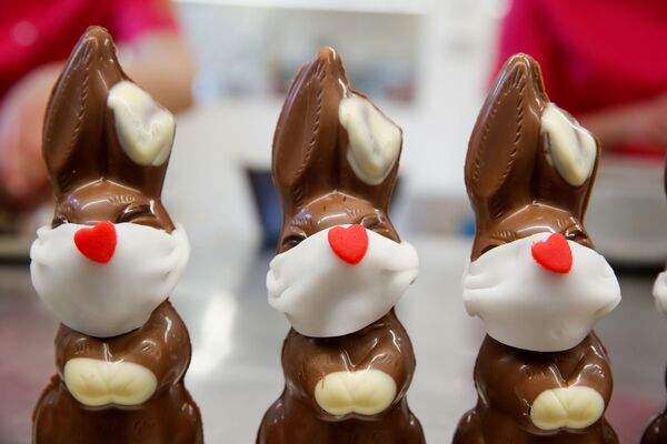 Шоколадные пасхальные кролики в защитных масках в пекарне Baeckerei Bohnenblust в Берне, Швейцария - Sputnik Казахстан