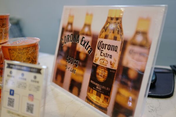 Вывеска с рекламой пива Corona со скидкой на стойке регистрации отеля Osaka Corona в Японии  - Sputnik Казахстан