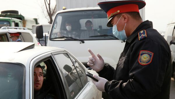 Сотрудник правоохранительных органов в маске беседует с водителем  - Sputnik Казахстан