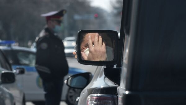 Мужчина в защитной маске отражается в боковом зеркале автомобиля в Алматы - Sputnik Қазақстан