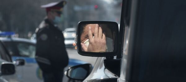 Мужчина в защитной маске отражается в боковом зеркале автомобиля в Алматы - Sputnik Казахстан