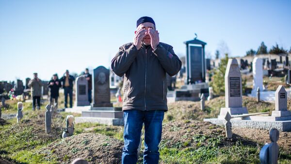 Мужчина молится во время обряда похорон на мусульманском кладбище, архивное фото - Sputnik Қазақстан