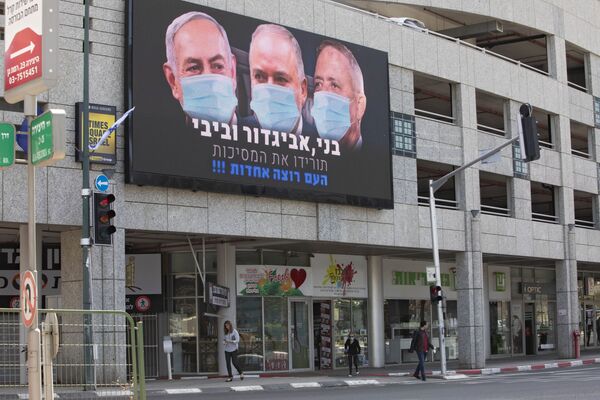 A billboard shows Israeli Prime Minister Benjamin Netanyahu, left, Israeli Former Defense Minister and leader of the Yisrael Beiteinu (Israel Our Home) right-wing party Avigdor Lieberman, center, and Blue and White party leader Benny Gantz, wearing masks in the Israeli city of Ramat Gan, near Tel Aviv, Sunday, March 29, 2020. Gantz, Netanyahu's chief rival, was chosen on Thursday as the new speaker of parliament, an unexpected step that could pave the way to a power-sharing deal between the two men as the country grapples with a worsening coronavirus crisis. The billboard calling for unity reads, Benny, Avigdor and Bibi take off your masks, the people want unity. 
 - Sputnik Казахстан