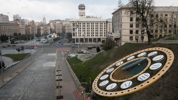 Показывающие полдень часы на фоне опустевшей площади Майдан Независимости в Киеве в период пандемии коронавируса - Sputnik Казахстан