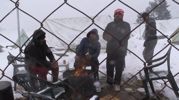 Беженцы грелись у костра в занесенном снегом лагере мигрантов в Салониках - Sputnik Казахстан