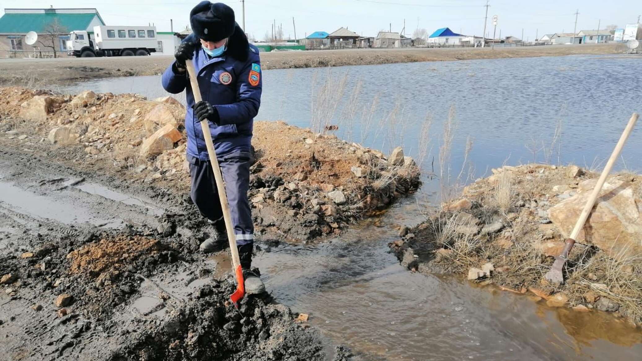 Поток воды переливается через дорогу