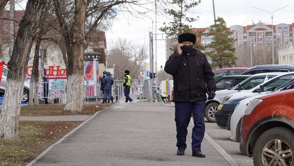 Пожилой мужчина во время карантина на улице говорит по мобильному телефону - Sputnik Қазақстан