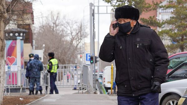 Пожилой мужчина во время карантина на улице говорит по мобильному телефону - Sputnik Казахстан