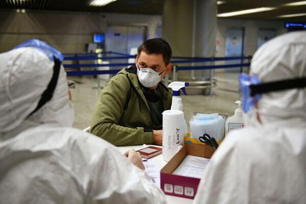 Медицинские работники во время проверки состояния пассажира в аэропорту Внуково - Sputnik Казахстан