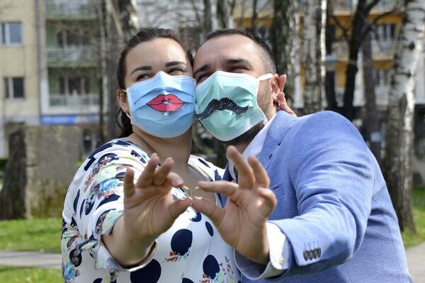 Snjezana Dacic, left, and her husband Rajko pose holding their rings and wearing masks during their wedding in Banja Luka, Bosnia, Saturday, March 21, 2020. For most people, the new coronavirus causes only mild or moderate symptoms. For some it can cause more severe illness.  - Sputnik Казахстан