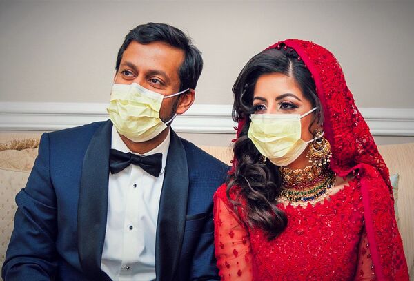 Doctors Kashif Chaudhry and Naila Shereen wear face masks after their wedding in New Windsor, New York, U.S., March 21, 2020 amid an outbreak of coronavirus disease (COVID-19). Picture taken March 21, 2020.   - Sputnik Казахстан