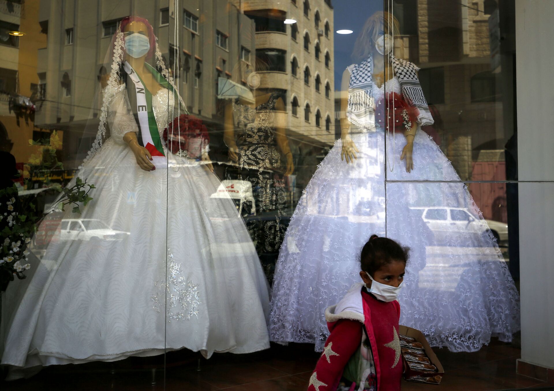 Девочка в защитной маске у витрины магазина со свадебными платьями в Газе - Sputnik Казахстан, 1920, 10.10.2023