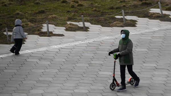 Люди в медицинских масках гуляют по улицам города - Sputnik Қазақстан