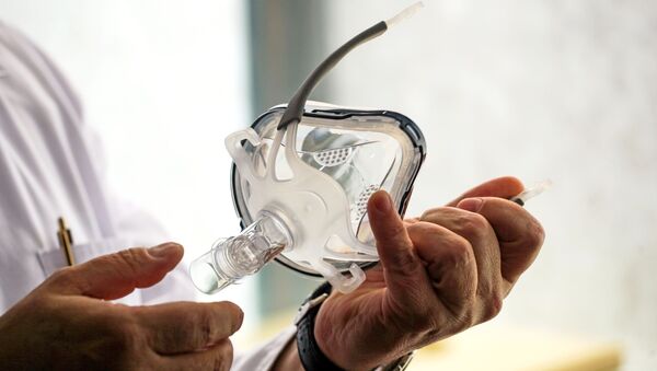 Врач держит в руках маску для искусственной вентиляции легких, иллюстративное фото - Sputnik Казахстан