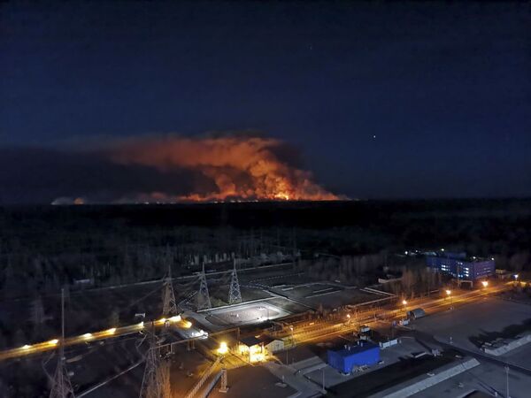 In this photo taken from the roof of Ukraine's Chernobyl nuclear power plant late Friday April 10, 2020, a forest fire is seen burning near the plant inside the exclusion zone.  Ukrainian firefighters are labouring to put out two forest blazes in the area around the Chernobyl nuclear power station that was evacuated because of radioactive contamination after the 1986 explosion at the plant.  - Sputnik Казахстан