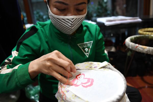 A worker makes colourful hand-embroidered face masks, used as a preventive measure against the spread of the COVID-19 novel coronavirus, at designer Do Quyen Hoa's workshop in Hanoi on April 13, 2020. 
 - Sputnik Казахстан