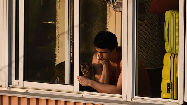Молодой человек с кошкой на балконе многоквартирного дома в Москве - Sputnik Казахстан