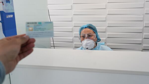 Пациент демонстрирует документы в регистратуре  - Sputnik Казахстан
