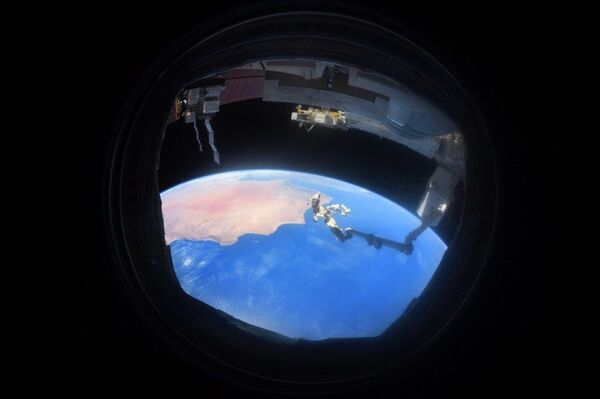 Снимок Земли через иллюминатор, сделанный на МКС космонавтом Антоном Шкаплеровым - Sputnik Казахстан