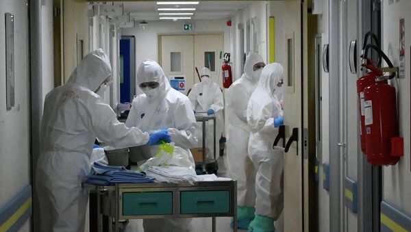 Медики в защитных костюмах дезинфицируют больницу - Sputnik Казахстан