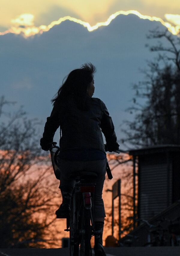 Велосипедистка на фоне заката в Берлине, Германия - Sputnik Казахстан