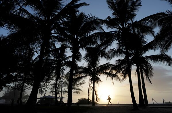 Мужчина гуляет во время заката на пляже в Рио-де-Жанейро, Бразилия - Sputnik Казахстан